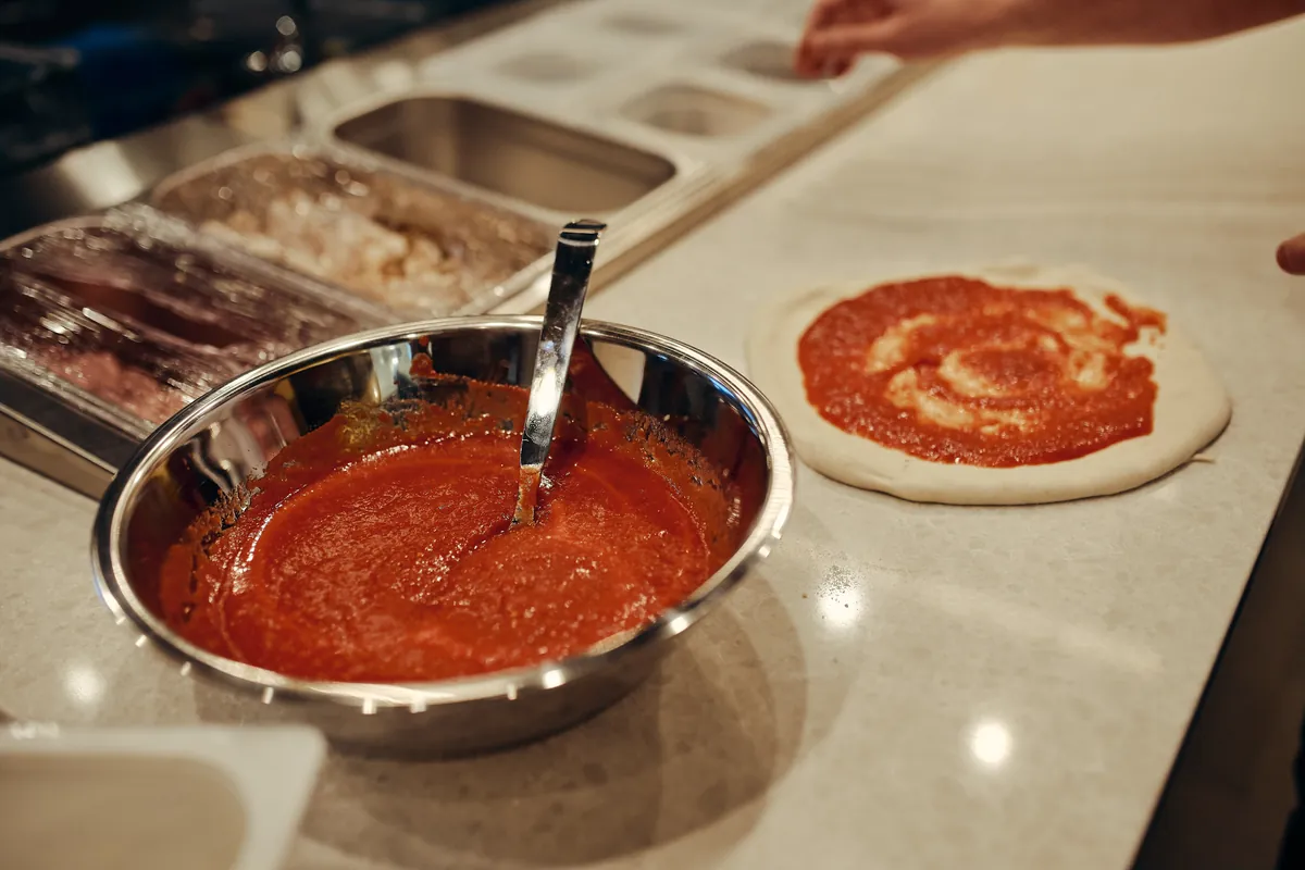 Lonec omake, spirala paradižnikove omake na testu.