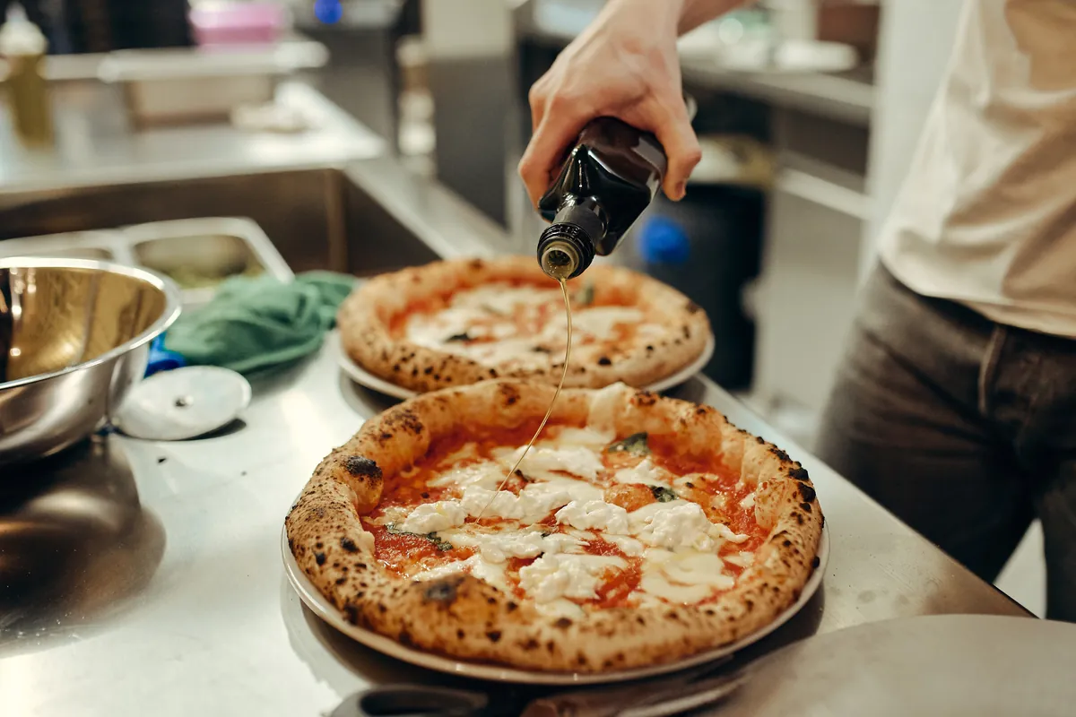 Oljčno olje se razlije na pico, dramatična kompozicija.